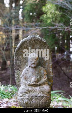 Piccola placca scultorea del Buddha Gautama ricoperta di licheni, tempio Saigandenji nel piccolo villaggio di Aso Kumamoto, in Giappone Foto Stock