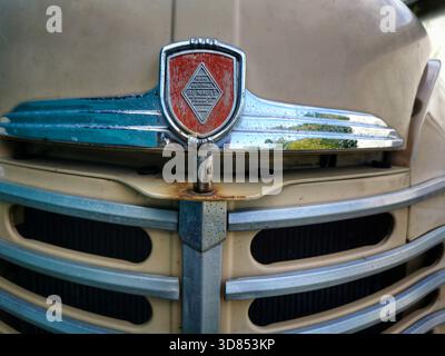 Questo mostra la griglia e il cofano di una vecchia automobile Renault. La parte anteriore presenta l'emblema Renault e mostra un po' di ruggine e usura sul veicolo Foto Stock