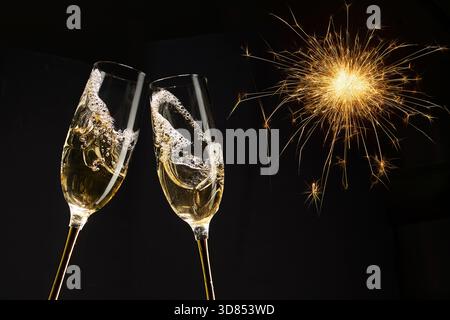 Buon anno, celebrazione con champagne. Due flute di champagne con scintillanti fuochi d'artificio Foto Stock