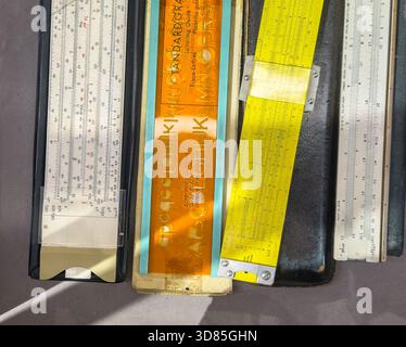 Collezione di guide per diapositive vintage e un modello di stencil con lettere disposte su un tavolo alla luce diretta del sole Foto Stock