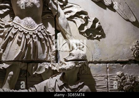 Dettaglio di un rilievo in pietra scolpita raffigurante un arcangelo che tocca la testa di un vescovo all'abbazia di Mont Saint-Michel. Primo piano di una scultura medievale in pietra. Foto Stock