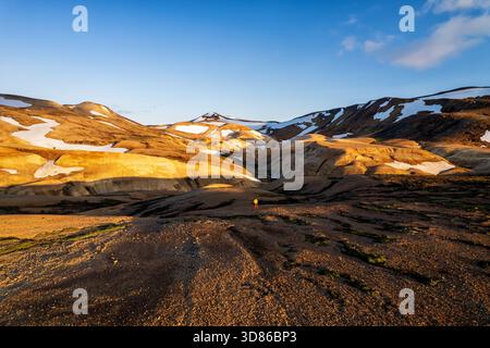 Vista aerea della luce del sole dorata che bagna il terreno accidentato di Kerlingarfjöll, dove le cime innevate incontrano la terra in un incredibile contrasto di colori, Foto Stock