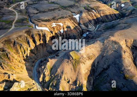 Vista aerea delle aspre montagne di Kerlingarfjöll, dove la luce balla sulle vette e le valli, creando un drammatico contrasto di ombre e alti Foto Stock