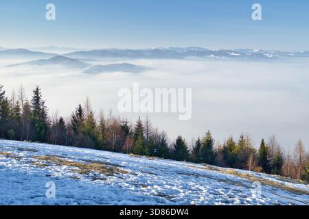 Vista aerea del tranquillo paesaggio con una coperta di nebbia che si snoda sulle montagne, Slubica, Spisska nova VES, Kosicky kraj, Slovacchia. Foto Stock