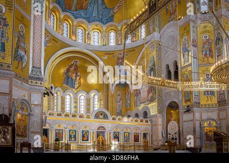 Belgrado, Serbia,13.06.22. Interno della Chiesa di San Sava con il grande lampadario centrale (coro), mosaici dorati con immagini Foto Stock