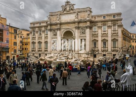 Vista della Fontana di Trevi con turisti e venditori ambulanti in Piazza di Trevi, Roma Foto Stock