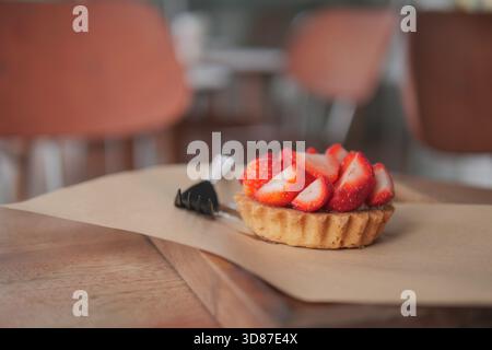 Crostata fresca di fragole su un tavolo di legno in un intimo caffè Foto Stock