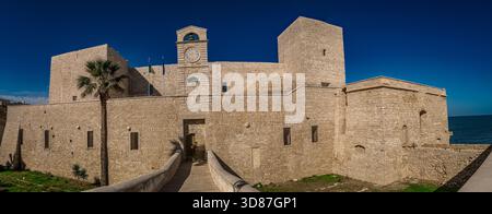Vista panoramica del castello normanno di Trani in Puglia con fossato, torri e palme Foto Stock