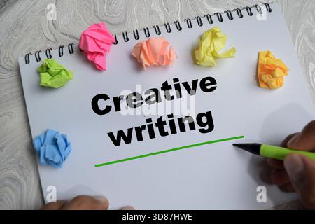 Concetto di scrittura creativa scrivere su libro isolato su tavolo di legno. Foto Stock