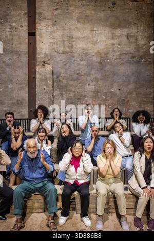 Il pubblico ha scioccato con diverse espressioni facciali seduti in piedi a teatro mentre guardano le rappresentazioni teatrali Foto Stock