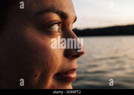 Primo piano di una donna sorridente che guarda lontano Foto Stock