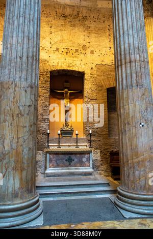 Una vista dell'altare all'interno del Pantheon a Roma, Italia, con un crocifisso e candele, che mostra la trasformazione dell'edificio da tempio romano Foto Stock