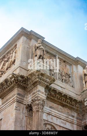Un'immagine a basso angolo dell'Arco di Costantino, Roma, Italia, che mostra le sue intricate sculture e statue, costruite per commemorare la vittoria di Costantino I. Foto Stock