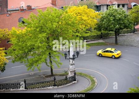 Prendere un taxi su una strada stretta e girare nella città vecchia Foto Stock