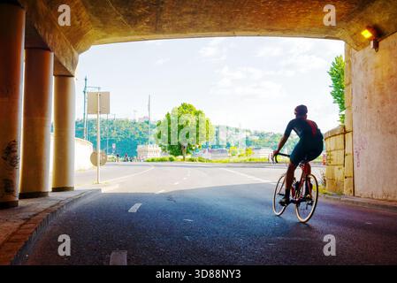 Silhouette del ciclista che esce dal tunnel Foto Stock
