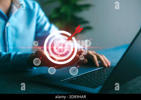 Obiettivo aziendale e concetto di targeting per il successo con un uomo che detiene il simbolo del target digitale, che rappresenta strategia, raggiungimento e pianificazione di precisione in un attimo Foto Stock