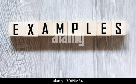 ESEMPI di parole scritte su blocchi di legno su sfondo grigio. Il concetto di leadership. Foto Stock