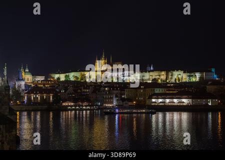 Vista notturna del Castello di Praga e della città minore con il fiume Moldava in primo piano Foto Stock
