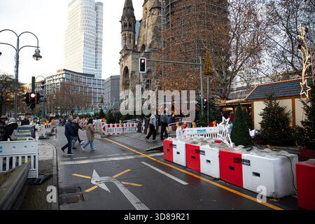 Berlino, Berlino, Germania. 29 novembre 2025. Sabato 29 novembre 2025, i visitatori hanno attraversato le barriere di sicurezza al mercato di Natale di Breitscheidplatz a Berlino, mentre la folla si muoveva attraverso le bancarelle che circondano la chiesa commemorativa del Kaiser Wilhelm. I blocchi rinforzati e i punti di ingresso recintati rimangono una caratteristica standard del sito, introdotta dopo precedenti problemi di sicurezza e ora parte del layout annuale del mercato. Nonostante le precauzioni visibili, il mercato ha attirato un costante traffico pedonale da parte di gente del posto e turisti che si godevano le bancarelle alimentari, le luci delle vacanze e l'inizio delle festività invernali di Berlino. ( Foto Stock