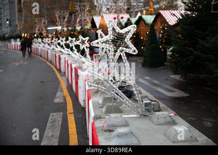 Berlino, Berlino, Germania. 29 novembre 2025. Sabato 29 novembre 2025, i visitatori hanno attraversato le barriere di sicurezza al mercato di Natale di Breitscheidplatz a Berlino, mentre la folla si muoveva attraverso le bancarelle che circondano la chiesa commemorativa del Kaiser Wilhelm. I blocchi rinforzati e i punti di ingresso recintati rimangono una caratteristica standard del sito, introdotta dopo precedenti problemi di sicurezza e ora parte del layout annuale del mercato. Nonostante le precauzioni visibili, il mercato ha attirato un costante traffico pedonale da parte di gente del posto e turisti che si godevano le bancarelle alimentari, le luci delle vacanze e l'inizio delle festività invernali di Berlino. ( Foto Stock