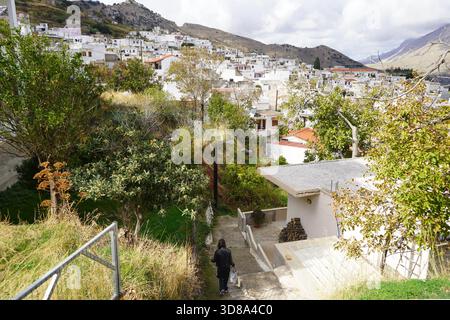 Ampia vista sul villaggio di Melampes, incastonato tra le montagne di Rethymno, Creta. Le case bianche si estendono lungo il pendio della montagna sotto un cielo spettacolare Foto Stock