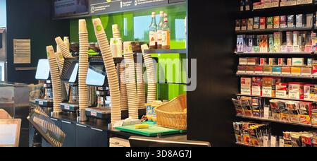Berlino, Germania - 25 settembre 2025: Caffetteria con distributori di bevande e scaffali di prodotti per i clienti. Foto Stock