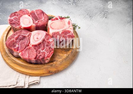 Ossobuco di vitello crudo in marmo, perfetta carne di gambo tagliata a croce per ricette tradizionali italiane e gustose cene di famiglia. sfondo bianco. v superiore Foto Stock
