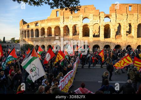 Roma, Italia. 29 novembre 2025. I manifestanti marciano davanti al Colosseo durante una manifestazione contro l'economia di guerra e a sostegno della Palestina a Roma il 29 novembre 2025. I manifestanti chiedono al governo italiano di smettere di fornire armi a Israele. Crediti: Insidefoto/Alamy Live News Foto Stock