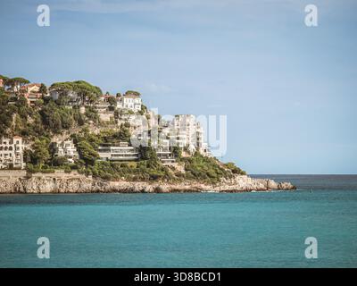 Una splendida vista delle lussuose ville sulle scogliere lungo la costa di Nizza, in Francia. Le limpide acque turchesi del Mar Mediterraneo si estendono Foto Stock