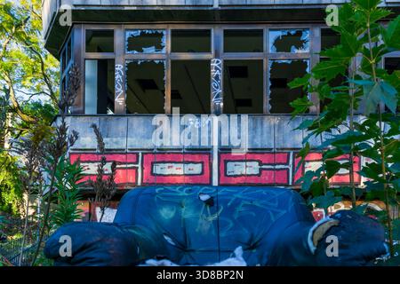 Poltrona abbandonata di fronte alla facciata di un edificio abbandonato, vegetazione sovrastata, Berlino, Germania. Foto Stock
