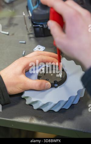 Il cacciavite fissa le viti a una ruota dentata in un ambiente di officina, Jugend Forschungszentrum Nagold, distretto di Calw, Germania Foto Stock