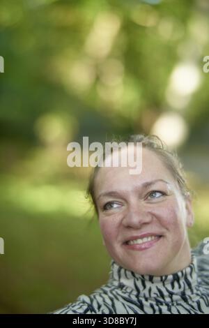Ritratto di una donna Ucraina matura entusiasta che sorride nel parco, ottimista, felice, sanguinosa con sorriso ottimista, calma felicità Foto Stock