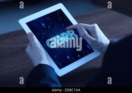 Regolamento generale sulla protezione dei dati. Uomo che usa un tablet con GDPR in esposizione, primo piano. Sicurezza della privacy Foto Stock