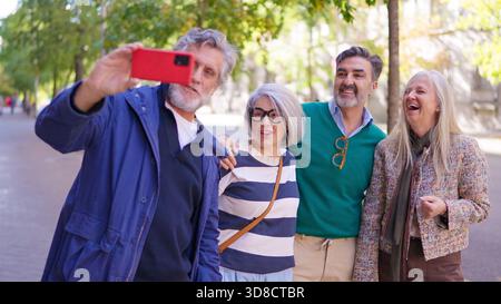 Amici anziani felici che fanno un selfie di gruppo all'aperto Foto Stock