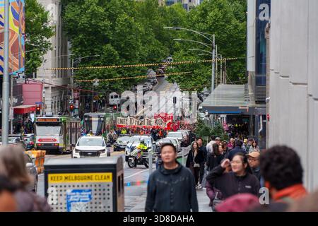 Melbourne, Victoria, Australia. 30 novembre 2025. - Una protesta con striscioni anti-razzismo e bandiere rosse procede lungo una strada trafficata a Melbourne, Australia, Foto Stock