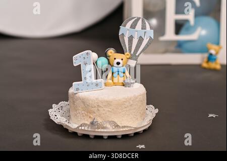 foto ravvicinata della torta di compleanno con un orso blu che regge il palloncino. la torta è decorata con il numero 1. la prima torta di compleanno con decorazioni per celebrità Foto Stock