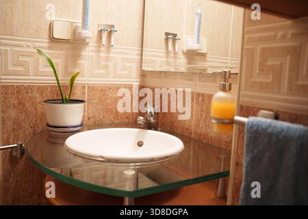 Accogliente bagno decorativo, elegante bagno con dettagli a mosaico e finiture cromate Foto Stock