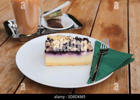 cheesecake ai mirtilli su una platte bianca su un tavolo di legno Foto Stock