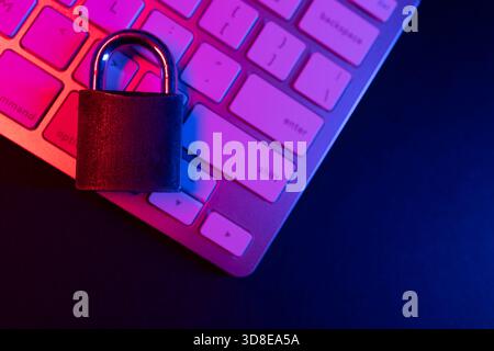 Un lucchetto è posizionato su una tastiera, a simboleggiare l'importanza della sicurezza informatica e della sicurezza su Internet. Questa scena enfatizza la protezione delle informazioni personali Foto Stock