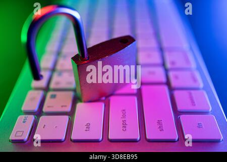 Un lucchetto poggia sulla tastiera di un computer, simboleggiando la sicurezza Internet e la protezione informatica. Foto Stock