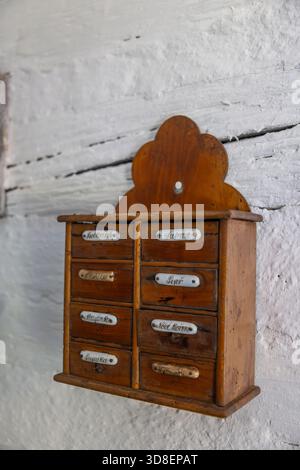 Armadietto vintage in legno con piccoli cassetti su una parete in legno imbiancato Foto Stock