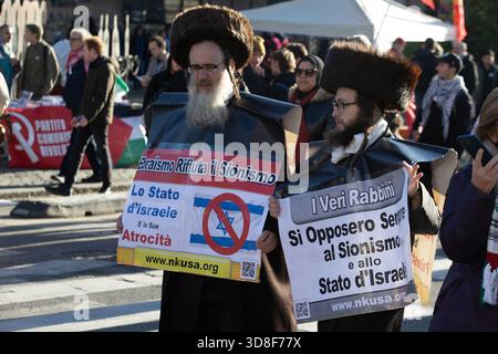 I membri ebrei ultra-ortodossi di Neturei Karta tengono cartelli anti-sionisti durante una manifestazione pro-Palestina a Roma, Italia - 29 novembre 2025 Foto Stock