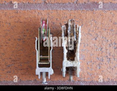 Rulli delle porte scorrevoli vecchi e nuovi in contrasto. Foto Stock