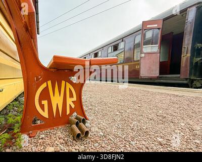 Lydney, Gloucestershire, Inghilterra, Regno Unito - 28 marzo 2025: Simbolo della GWR Great Western Railway su una panchina su una piattaforma della Dean Forest Railway Foto Stock