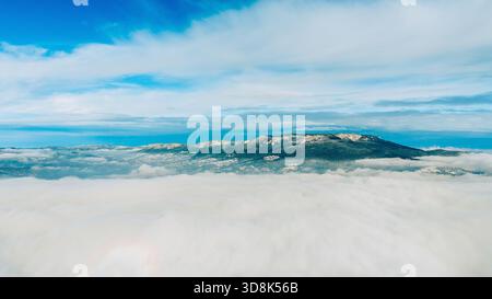 Il picco della montagna Romanija che emerge sopra un profondo strato di nebbia, ideale per campagne turistiche, immagini di viaggio invernali, concetti paesaggistici ispiratori e pulito Foto Stock