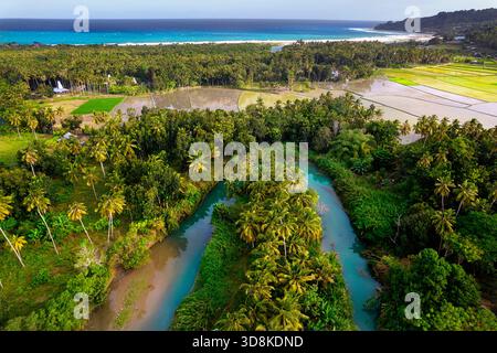 Vivaci campi di riso pieni d'acqua al tramonto sull'isola tropicale di Sumba, che mostrano bellissime piscine di riflessione a terrazze in Indonesia Foto Stock
