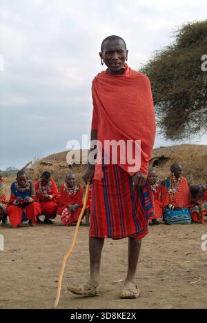 Masai Mara, Kenia - 23 agosto 2010: Uomo locale e gruppo di donne africane non identificate della tribù Masai in abiti di cotone multicolore e gioielli in perline Foto Stock