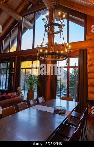 Accogliente cabina rustica soggiorno con grandi finestre e caldi interni in legno nelle Alpi Ausrtiane . Foto Stock