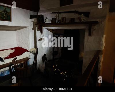 Knock, Irlanda - 22 ottobre 2025: Interno storico cottage a Knock, Irlanda, con caminetto illuminato, travi in legno e oggetti da collezione vintage. Foto Stock