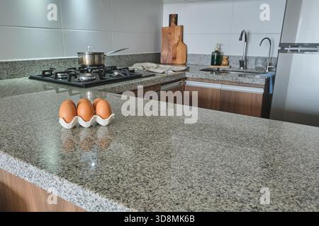Uova appoggiate su un elegante ripiano in granito in una cucina contemporanea Foto Stock